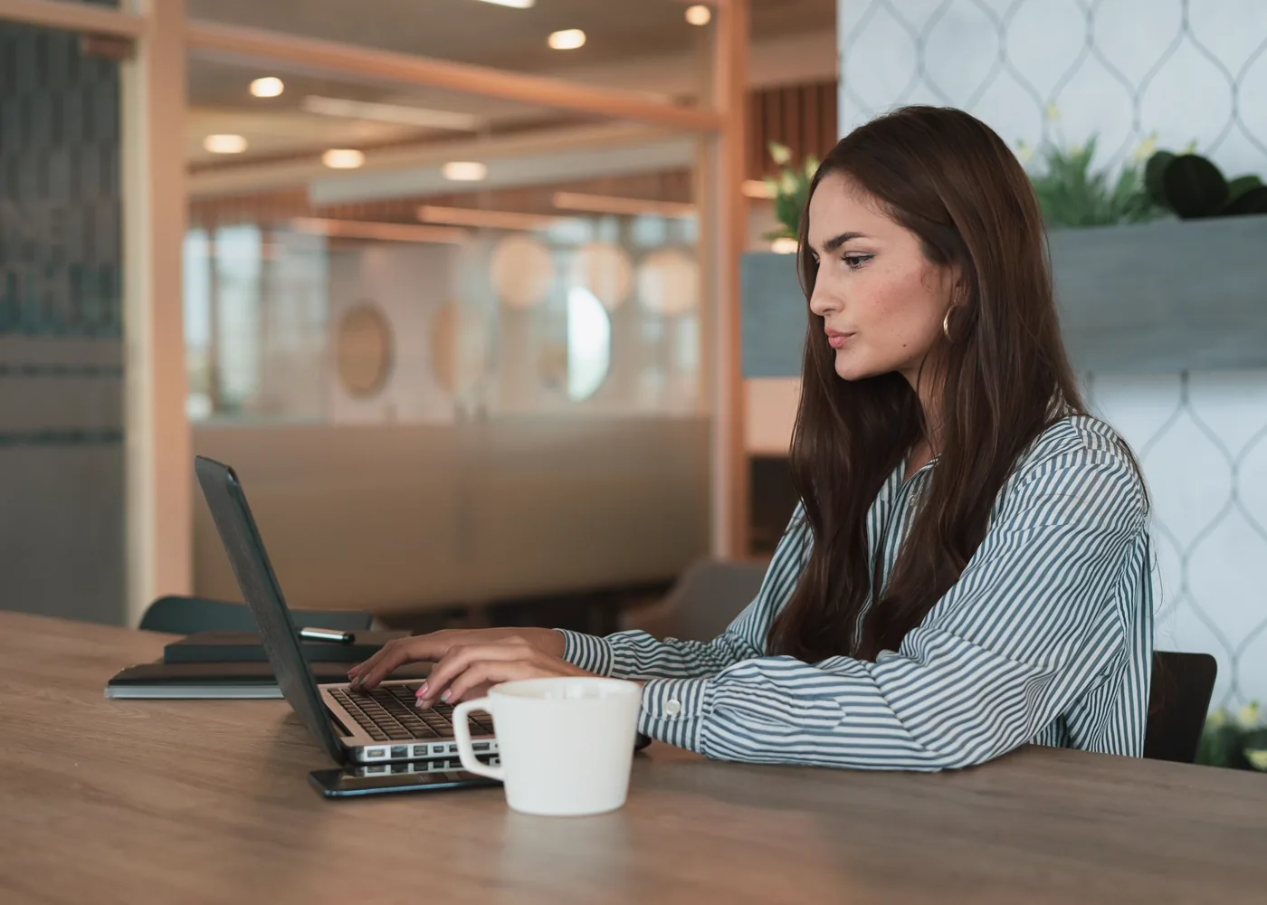 Une professionnelle travaille à son bureau, concentrée sur son projet.