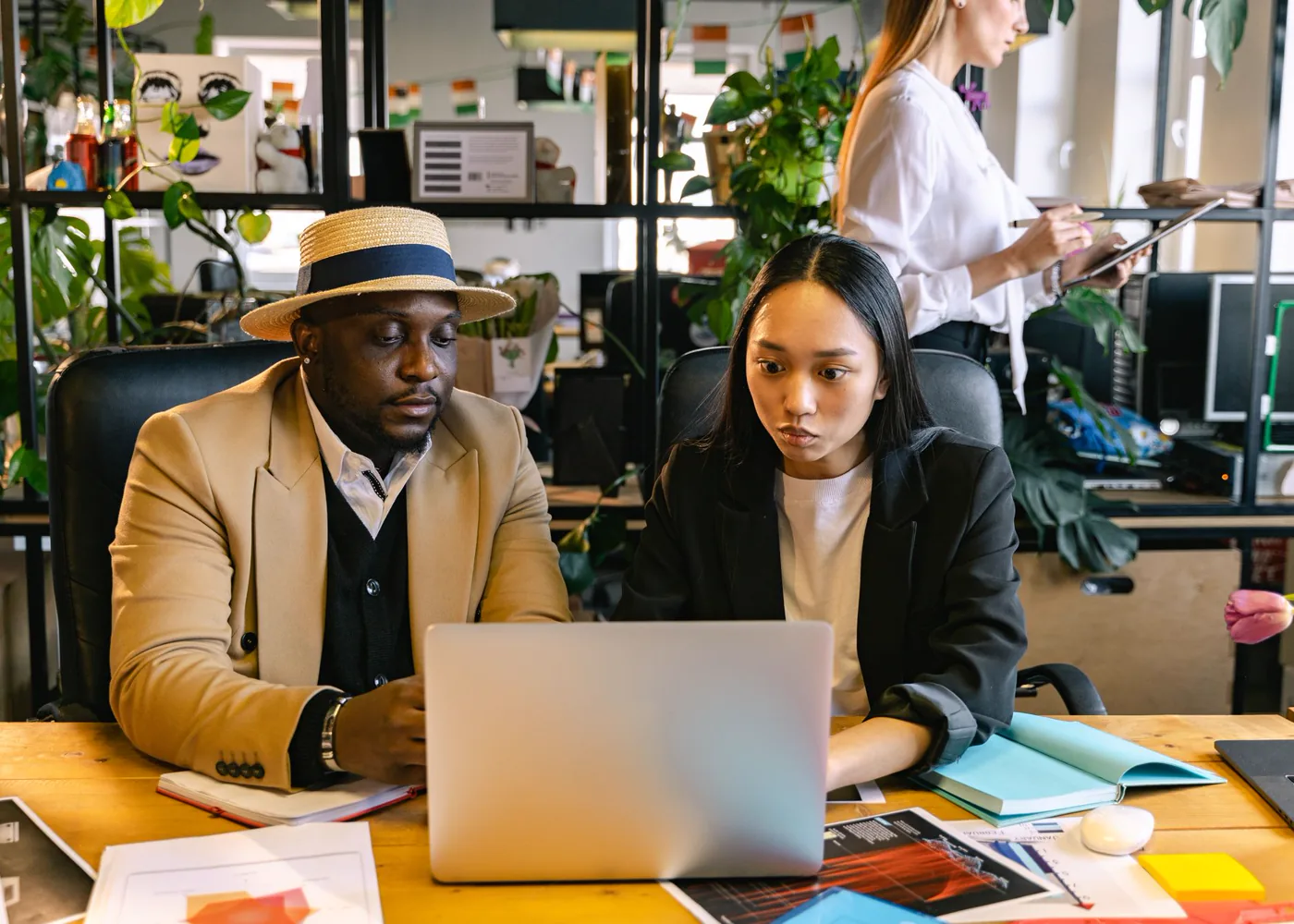 Deux professionnels échangent devant un ordinateur portable.