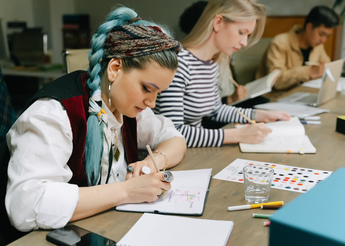 Un groupe prend des notes et travaille ensemble autour d’une table.